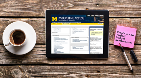 IPad loged into U-M Wolverine Access with cup of coffee next to it.